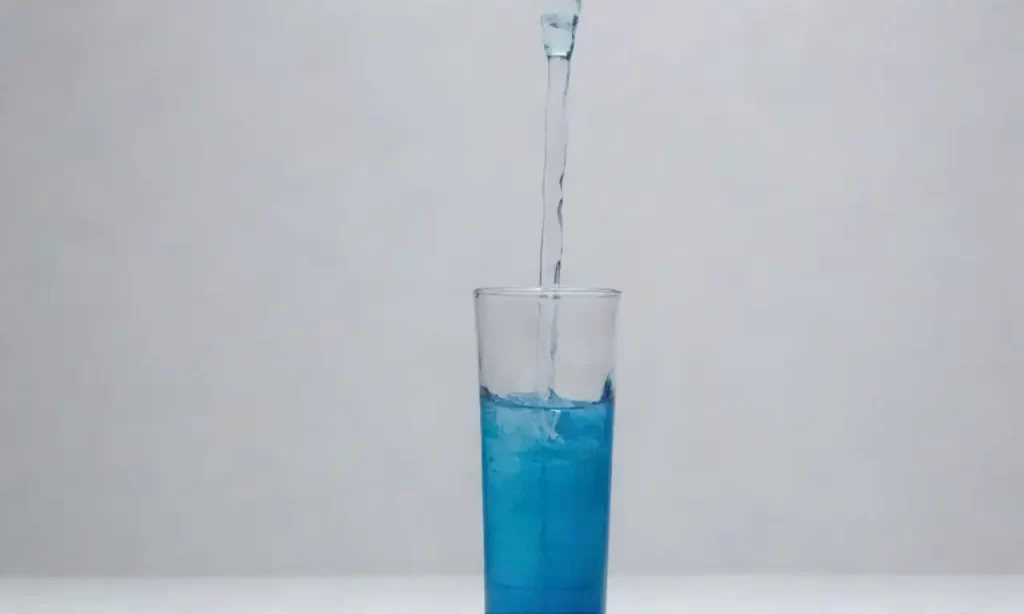 Un bocal de agua azul contra un fondo blanco